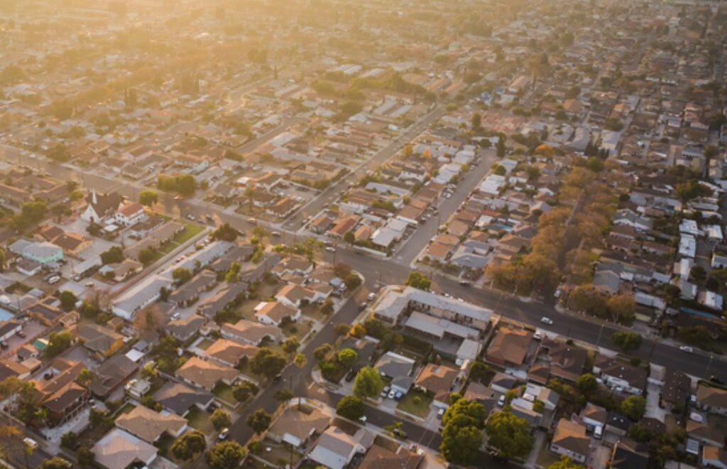 aerial view of a city's grid layout and neighborhoods at either sunrise or sunset