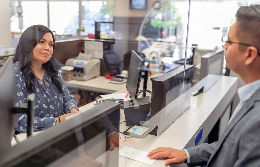 bank teller and customer transacting business at the window