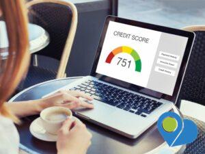 woman with cup of coffee and laptop showing credit score 751