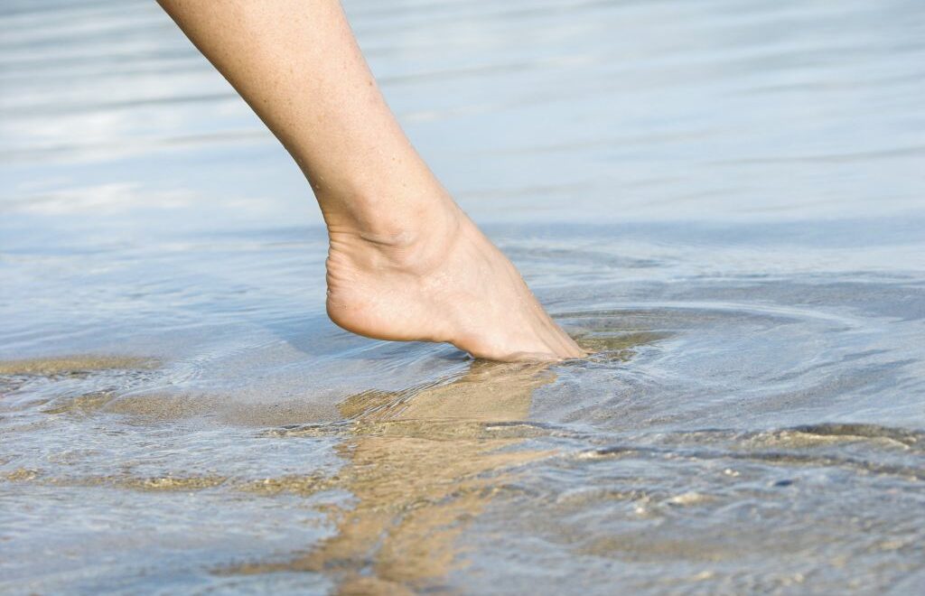 photo of one leg and dipping toes in the water