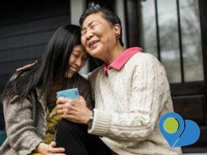 mother holding a coffee mug and daughter embracing on the front porch of their house
