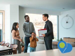 woman, man, child together with a real estate agent holding folder and papers in a living room looking happy