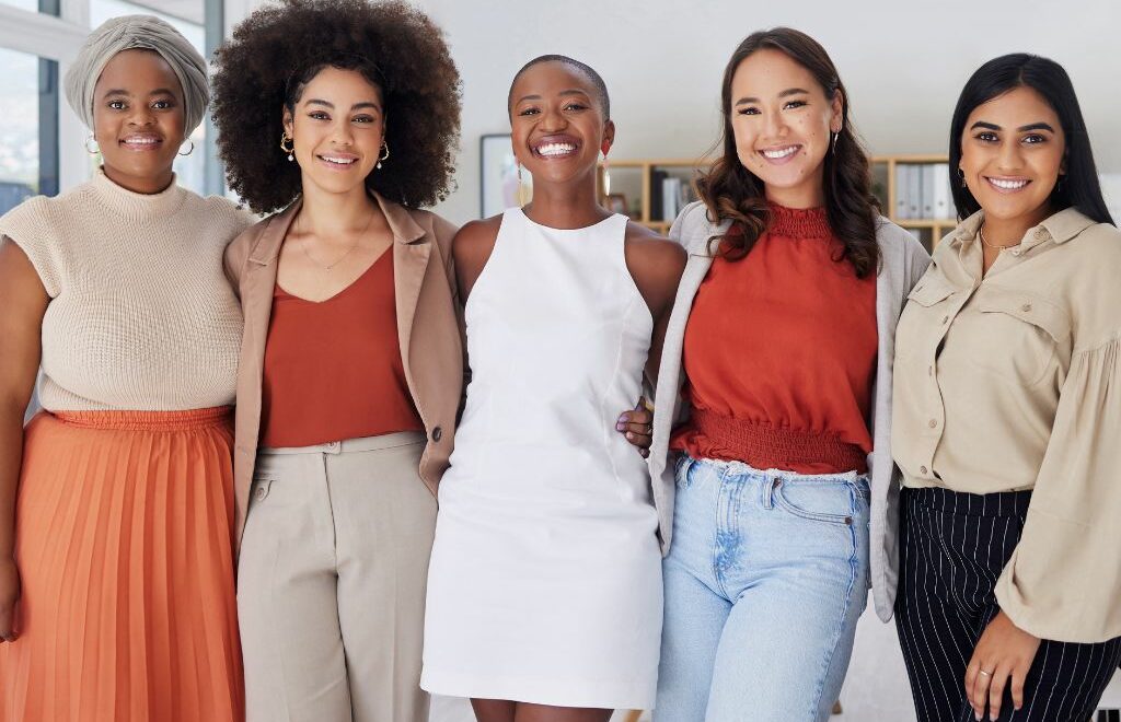 five attractive women standing together looking happy and empowered