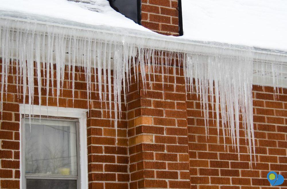 House in winter with icicles hanging over roof