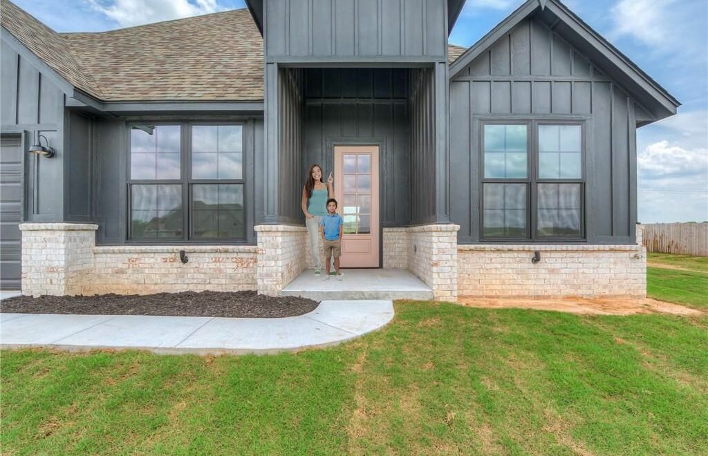 new construction home with woman and son standing on front porch