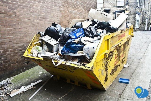 Dumpster full of trash in alley