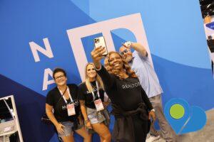 Group of attendees at the 2023 NAR NXT annual conference taking a selfie in the expo hall